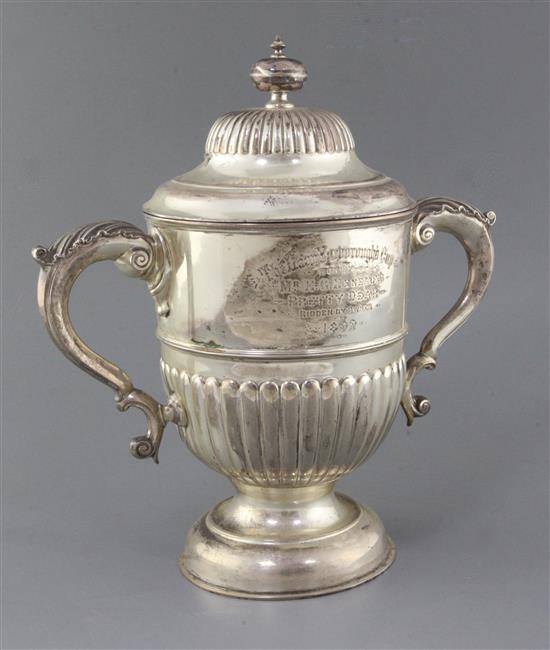 A late Victorian demi-fluted silver two handled pedestal presentation cup and cover, by John Newton Mappin, 47.4 oz.